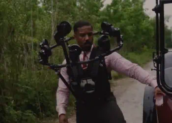 Warner Bros. Pictures reveals how twin scenes in Sinners were filmed using the innovative Halo Rig—featuring 10–12 cameras to capture Michael B. Jordan’s face and map it onto a stunt double in 50% of twin appearances.