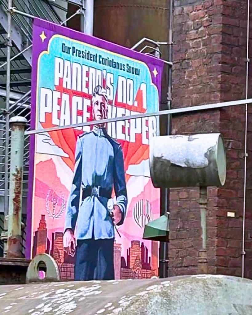 The first look at Ralph Fiennes as President Snow in The Hunger Games: Sunrise on the Reaping has been revealed, showcasing a propaganda-style poster from the film’s set in Germany.