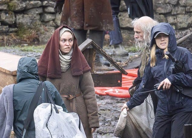 The first look at Lily-Rose Depp on the set of Robert Eggers’ Werwulf in Bourne Wood, England. Depp appears nearly unrecognizable in a gritty, medieval-inspired costume that reflects the film’s dark historical tone.