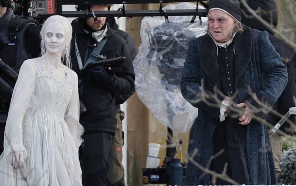 First look images reveal Johnny Depp as Ebenezer Scrooge and Andrea Riseborough as the Ghost of Christmas Past on the London set of Ti West’s Ebenezer: A Christmas Carol.